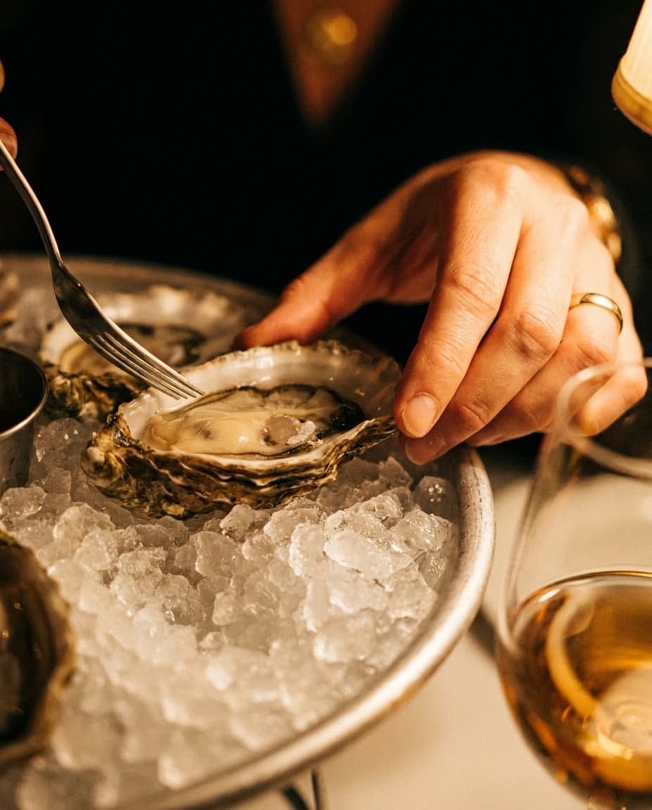 Oesters op ijs met een glas witte wijn